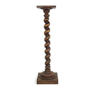 May include: A wooden pedestal with a square top and a twisted, spiral column. The pedestal is made of dark brown wood and has a rustic, antique look.