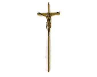 May include: A gold-toned crucifix with a wooden cross and a metal figure of Jesus Christ.