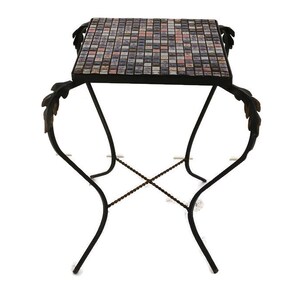 May include: A black metal side table with a mosaic tile top. The table has a decorative leaf design on the legs.