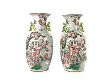 May include: Two white porcelain vases with green, yellow, and red floral and dragon designs. The vases have a wide mouth and a narrow neck.