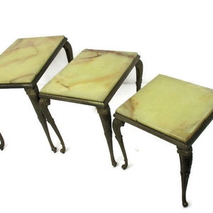Può includere: Set di tre tavolini a incastro con piani in marmo verde e gambe in ottone ornate.