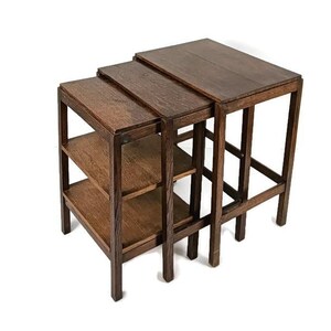 Könnte beinhalten: Ein Satz aus drei verschachtelten Holztischen mit einer dunkelbraunen Oberfläche. Die Tische sind aus massivem Holz gefertigt und haben ein schlichtes, elegantes Design.