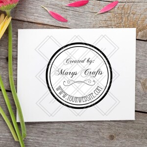 May include: A white card with a black circular logo that reads "Created by: Marys Crafts" and "www.yourwebsite.com". The card is on a wooden surface with three gerbera daisies in orange, yellow, and pink.