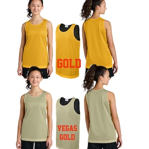Pode incluir: Duas mulheres vestindo camisas de basquete de malha amarela e bege. As camisas t&ecirc;m o texto "GOLD" e "VEGAS GOLD" impresso nelas.