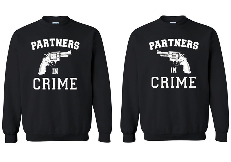 May include: Two black sweatshirts with white text that reads "Partners in Crime" and a graphic of a revolver.