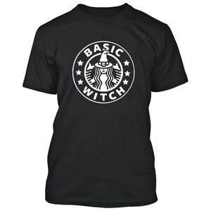 May include: Black t-shirt with a white graphic of a witch wearing a hat and the text "Basic Witch" in a circle.