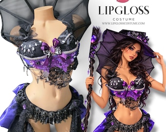 May include: A black and purple costume set featuring a structured bodice with lace, ribbons, and a central purple gem, paired with a matching skirt, a wide-brimmed hat, and a bat-wing accessory. Text reads LIPGLOSS COSTUME WWW.LIPGLOSSCOSTUME.COM.