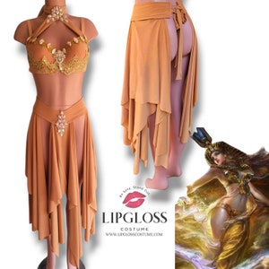 Puede incluir: Un conjunto de disfraz dorado y marrón con un top halter, una falda con una abertura alta y un cinturón a juego. La falda tiene un diseño en capas y es asimétrica. El disfraz está inspirado en la mitología egipcia y presenta un diseño con joyas.