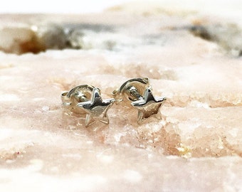 May include: A pair of silver star stud earrings. The earrings are small and delicate, with a simple design.