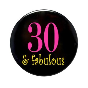 May include: A black button with the number 30 in pink and the text "& fabulous" in yellow.