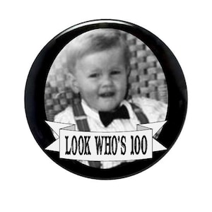 May include: Black and white photo of a young boy wearing a bow tie and a white shirt with the text "Look Who's 100" on a banner.