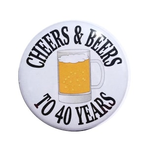 May include: A white button with the text "CHEERS & BEERS TO 40 YEARS" in black. A beer mug graphic is in the center, filled with golden beer and white foam. The button is round and has a glossy finish.