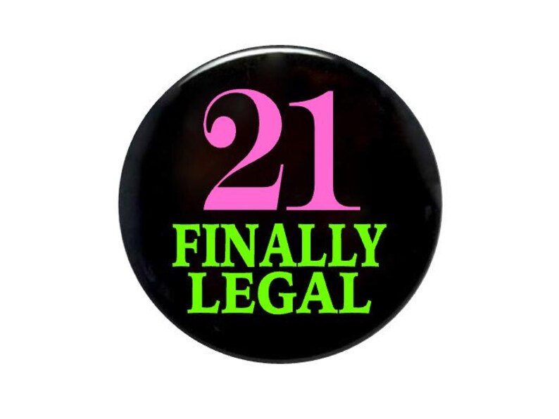 May include: A black button with the number 21 in pink and the words "FINALLY LEGAL" in green.