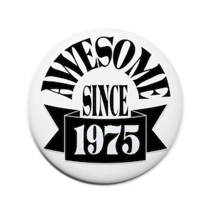 May include: Black and white button with the text "Awesome Since 1975" in a retro font.