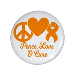 May include: White button with an orange peace sign, heart, and ribbon. The text "Peace, Love & Cure" is written below the symbols.
