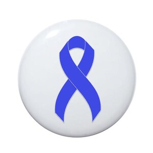 May include: A white button with a blue ribbon in the center. The ribbon is tied in a bow.