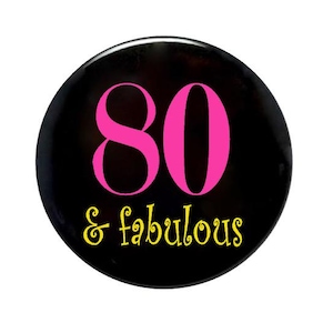 May include: A black button with the number 80 in pink and the text "& fabulous" in yellow.