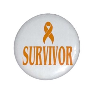 May include: White button with an orange ribbon and the word "SURVIVOR" in orange.