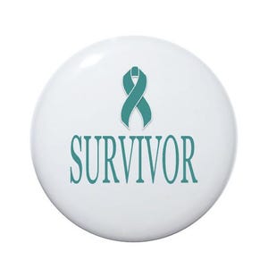 May include: A white button with a teal ribbon and the word "SURVIVOR" in teal lettering.