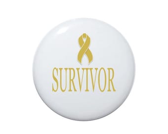 May include: White button with a gold ribbon and the word "SURVIVOR" in gold lettering.