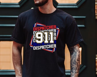 以下が含まれることがあります： 白い文字と金のアウトラインで911の数字が描かれた黒のTシャツ。数字は赤、白、青の正方形で囲まれており、白い文字で「DISPATCHER」と書かれている。