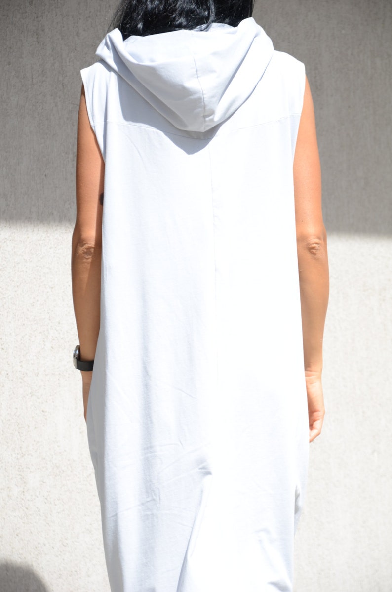 May include: A sleeveless hooded dress in a light gray color. The dress has a loose fit and a long, flowing silhouette.