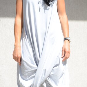 May include: A light gray sleeveless hooded dress with a gathered, loose fit.