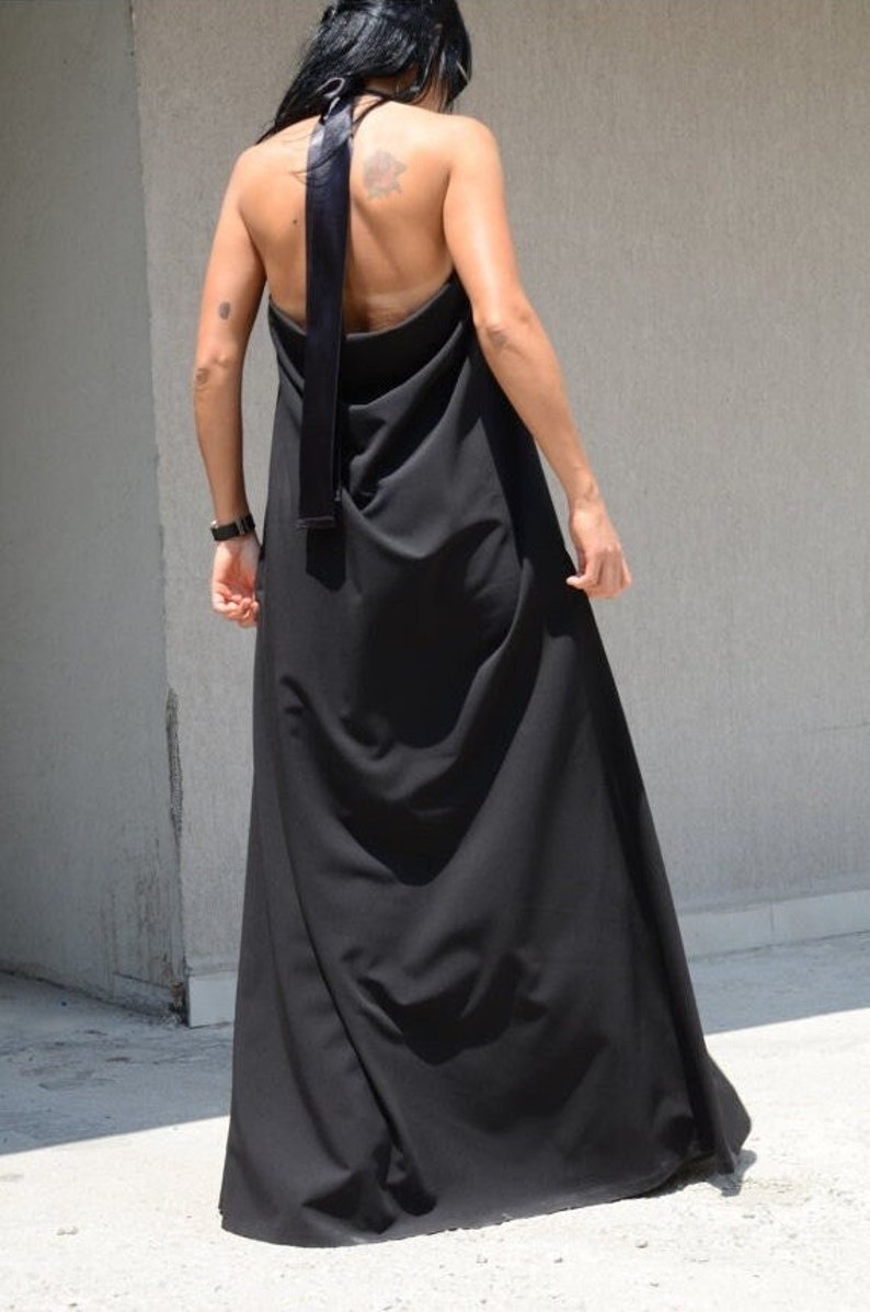 Pu&ograve; includere: Un abito maxi nero con scollo halter e gonna lunga e fluida. L'abito &egrave; realizzato in un tessuto morbido e confortevole e ha un design semplice ed elegante.