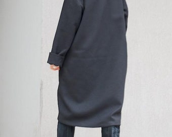 May include: A black long-sleeved tunic with a high collar and a relaxed fit. The tunic is made of a soft, comfortable fabric and is perfect for layering.
