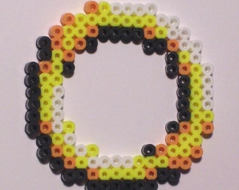 May include: A circular bead bracelet made with black, white, yellow, and orange beads.