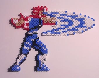 May include: Pixel art figure of a character in a dynamic pose, crafted from colorful beads. The figure is primarily blue, with red hair and accents, and a white and blue energy blast emanating from the arm. The figure is on a white background.
