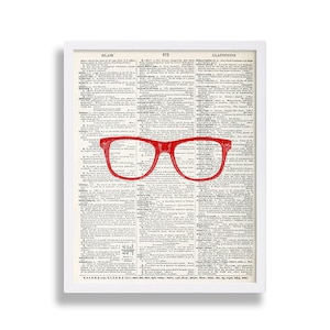 May include: Red plastic framed glasses on a vintage dictionary page with the word "glair" at the top of the page. The page is filled with text in a black font.