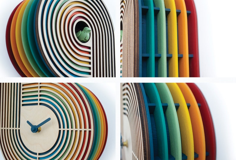 May include: A colorful wooden clock with a rainbow design. The clock face is white with black hands and a small bird cutout in the top right corner.