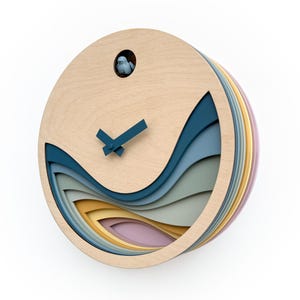 May include: A round wooden clock with a cuckoo bird, featuring a layered design of blue, green, yellow, and pink waves. The clock hands are blue.