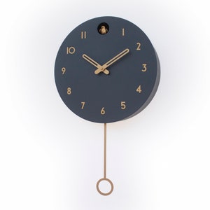 May include: A dark blue round clock with gold accents and a pendulum. The clock face has Roman numerals and a cuckoo bird at the top.