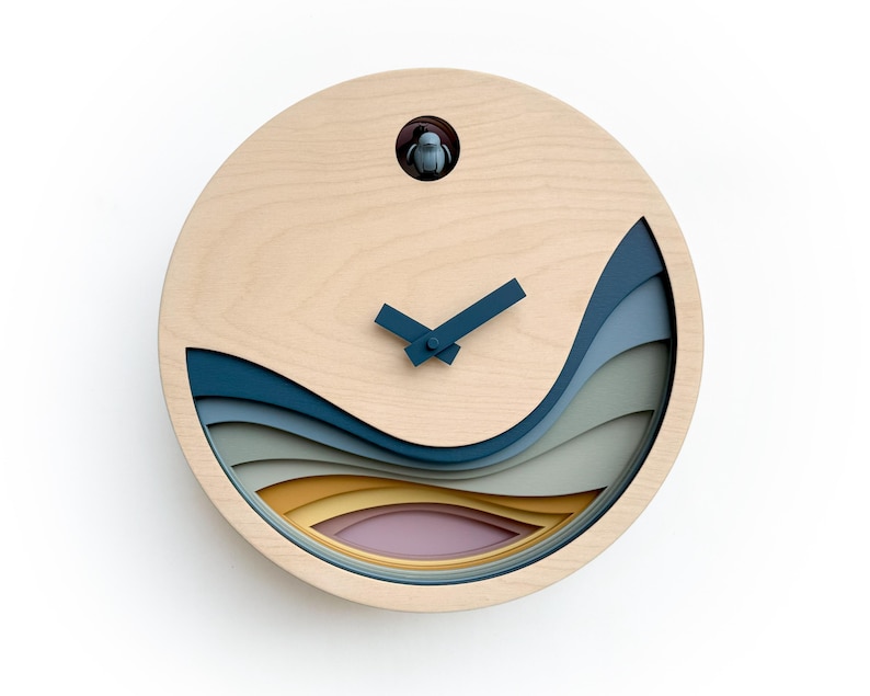 K&ouml;nnte beinhalten: Eine Holzkuckucksuhr mit einem geschichteten Design aus blauen, gr&uuml;nen, gelben und rosa Wellen. Die Uhr hat einen traditionellen Kuckucksvogel und Zeiger.