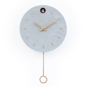 May include: A grey round cuckoo clock with gold hands and a gold pendulum. The clock has a textured surface and a small bird on the top.