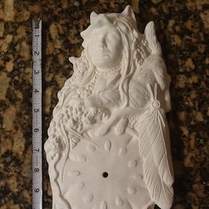 May include: White ceramic clock face with a Native American woman and a wolf design. The clock face is blank and ready to be painted.