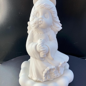 Könnte beinhalten: Weiße Keramikengelfigur, die eine Kerze hält und auf einem Wolkensockel steht. Der Engel hat einen Heiligenschein und langes Haar.