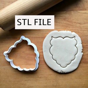 May include: White plastic cookie cutter in the shape of a decorative frame, with a sample of the cut-out shape in white dough on a wooden surface. The text "STL FILE" is printed on the surface.