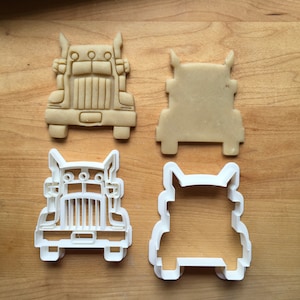 May include: Two cookie cutters in the shape of a semi-truck. One is white plastic and the other is made of brown dough.