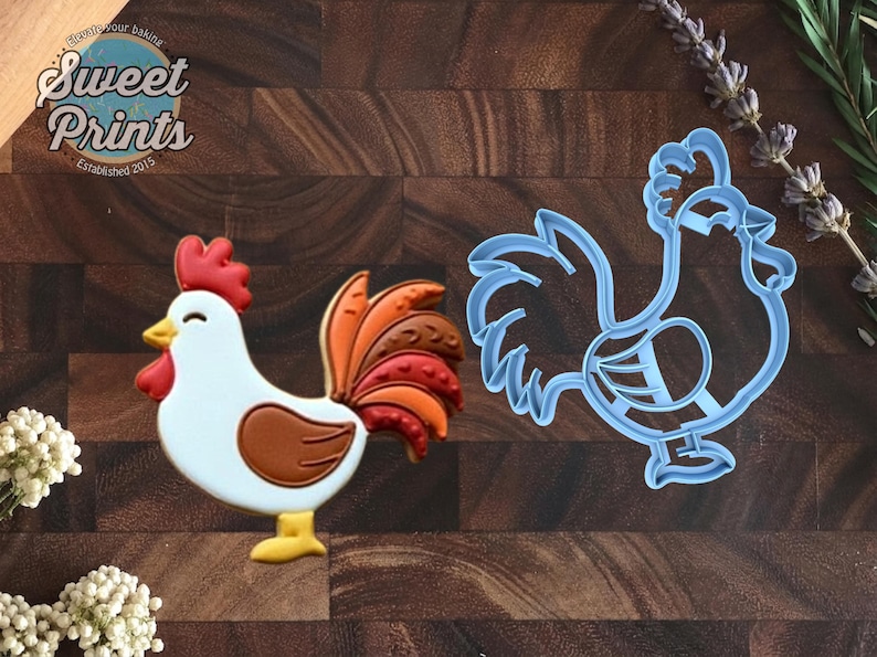 May include: A rooster-shaped cookie decorated with white icing, a red comb and wattle, a brown wing, and a multi-colored tail in shades of orange and brown, alongside a light blue plastic rooster-shaped cookie cutter with a detailed outline.