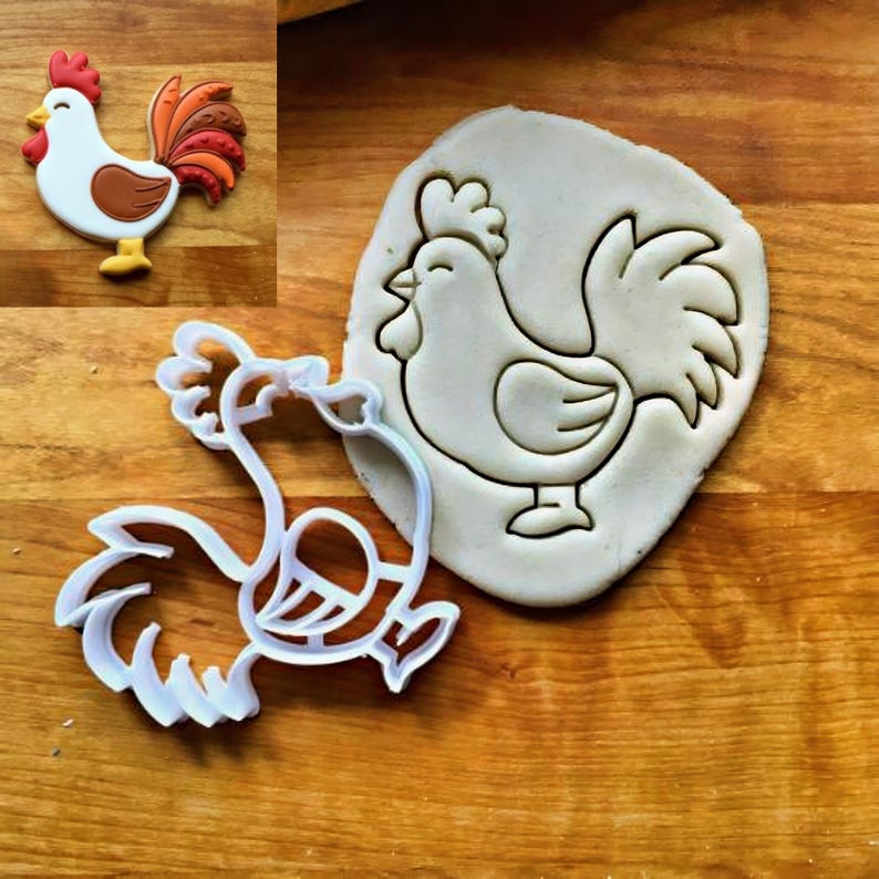 May include: A white plastic rooster-shaped cookie cutter next to a piece of dough embossed with the same rooster design, accompanied by a small inset image showing a finished cookie decorated with white, brown, orange, and red icing.