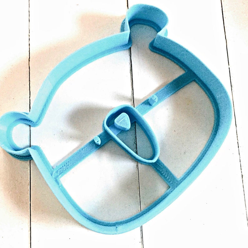May include: A light blue plastic cookie cutter shaped like a bear with a separate cutter for the nose.