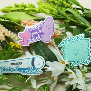 May include: Three colorful stickers with playful messages. The first sticker is purple and pink with the text "I've got your back". The second sticker is blue and white with the text "good vibes". The third sticker is green and blue with the text "stay safe".