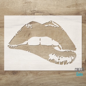 May include: White stencil of a pair of lips with a detailed outline. The stencil is on a wooden background.