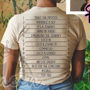 Puede incluir: Una camiseta beige con una lista de frases motivacionales impresas en la espalda. Las frases incluyen "Trust the Process", "Patience is Key", "It's a Journey", "Hang in There", "Embracing the Journey", "Loc'd In", "Loc'd & Loving It", "Committed", "Loc'd N Loaded", "Loyal", "Big Loc Energy", "In It for the Long Run", "#Goals", y "Top Tied". La parte delantera de la camiseta tiene la frase "Trust the Process" impresa.