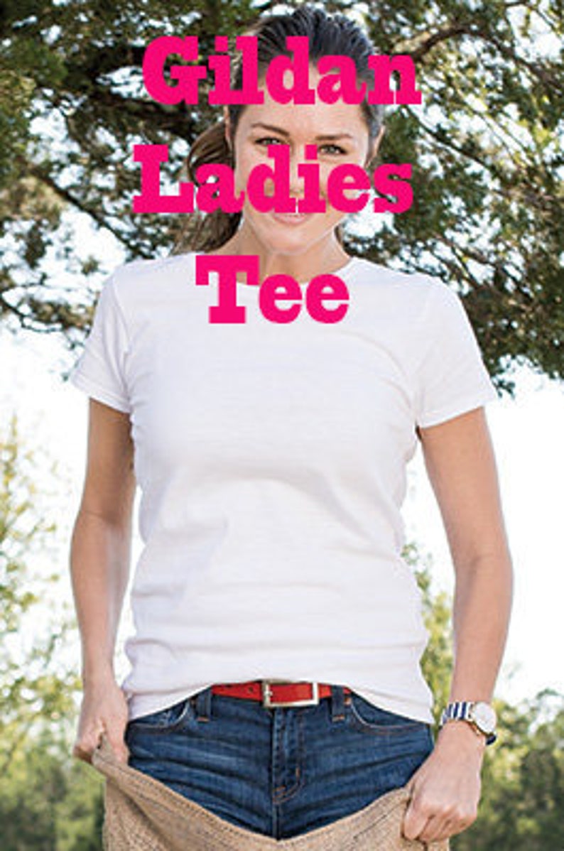 Puede incluir: Una camiseta blanca Gildan Ladies Tee. La camiseta es lisa y tiene cuello redondo.