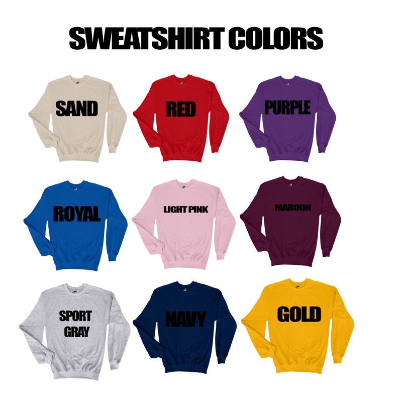 May include: A display of nine crewneck sweatshirts in various colors, including sand, red, purple, royal blue, light pink, maroon, sport gray, navy, and gold. Each sweatshirt has the color name printed in bold black letters.