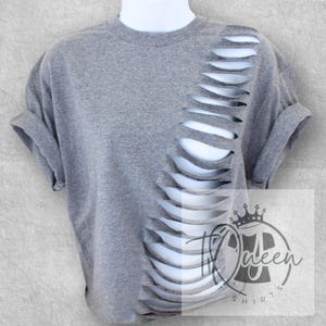 May include: Gray short-sleeved t-shirt with a vertical row of slits down the side. The t-shirt is cropped and has a relaxed fit.